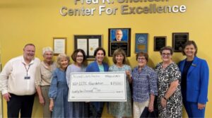 Group of people with a check presented by SecondLookCharities.